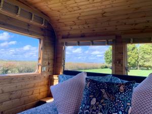 a view from the inside of a tiny house with two windows at The Showman, Luxury Camper in Halford