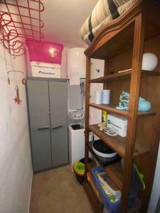 a small kitchen with a refrigerator and a shelf at Apartamento Mare Nostrum Centro Aguamarga in Agua Amarga