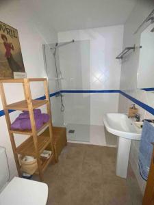 een badkamer met een douche, een toilet en een wastafel bij Apartamento Mare Nostrum Centro Aguamarga in Agua Amarga