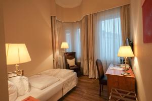 Cette chambre comprend un lit, une table et un bureau. dans l'établissement Self-Service by Hotel Savoy Hannover, à Hanovre