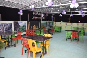 Hotel Karan International ,Aurangabad في أورانغاباد: غرفة طعام مع طاولات وكراسي ملونة