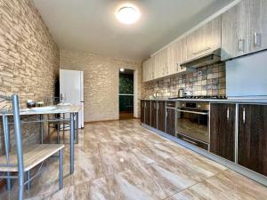 una grande cucina con armadi in legno e tavolo di ApartPoltava a Poltava