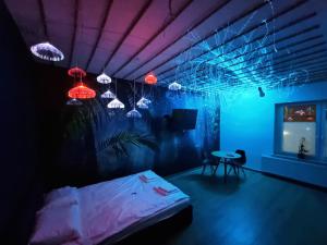 a room with a bed and a table and lights at Jacuzzi Katowice - Avatar in Katowice