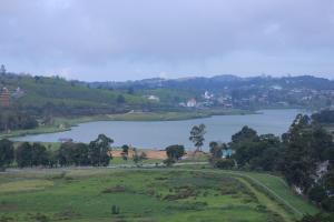 a view of a lake with trees and houses at Araliya Red - Lean Luxury - Where you find stunning 360 panoramic view of Nuwara Eliya in Nuwara Eliya