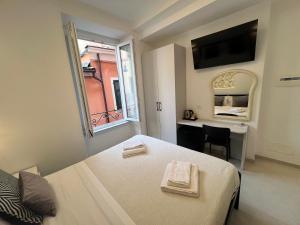 a bedroom with a bed and a desk and a window at Affittacamere Sull'Arco in Monterosso al Mare