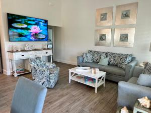 a living room with a couch and a flat screen tv at Sunshine retreat Elevated New Build walkable to everything including BEACH in Fort Myers Beach