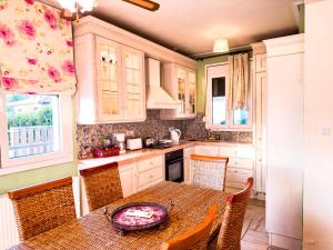 una cucina con tavolo e alcune sedie, un tavolo e una finestra di Blue Bay Villa a Volos