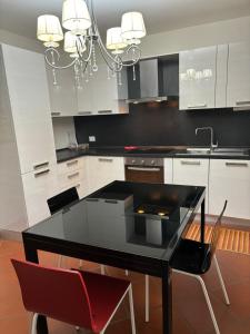 une cuisine avec une table noire et des chaises rouges dans l'établissement VILLA ISELLA, à San Venanzio