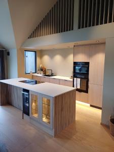 a large kitchen with a large island in the middle at Perle ved sjøen! Ny hytte på 90m2. in Kragerø