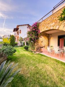 uma casa com um jardim com mesas e cadeiras em Blue Bay Villa em Volos