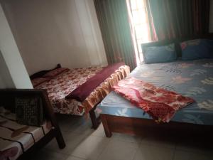 een slaapkamer met 2 bedden en een raam bij Green Haven Guest Inn in Badulla