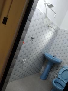 a bathroom with a blue toilet and a sink at Green Haven Guest Inn in Badulla