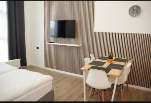 a dining room with a table and chairs and a tv at Sweet Rooms in Bubesheim