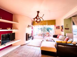 uma sala de estar com um sofá e uma televisão em Blue Bay Villa em Volos