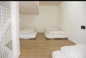 Habitación con 2 camas, paredes blancas y suelo de madera. en Sweet Rooms, en Bubesheim