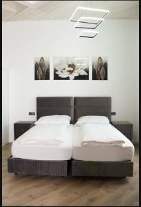 two beds in a bedroom with two paintings on the wall at Sweet Rooms in Bubesheim