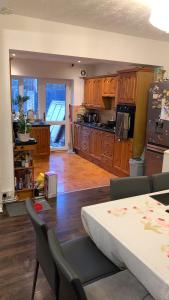 una cocina con armarios de madera y una mesa con sillas. en Adam Guest House en Leicester