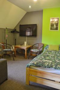 a bedroom with a green wall with a bed and a table at Agroturystyka w Świcie in Tuchola