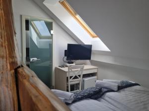 a room with a bed and a desk with a television at AZUR ROOMS LJUBLJANA in Ljubljana