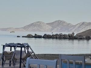 due sedie e un tavolo su una spiaggia vicino all'acqua di Lydia Mare ad Agios Kirykos