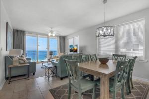 a dining room and living room with a table and chairs at Summerwind Center 1304 in Navarre