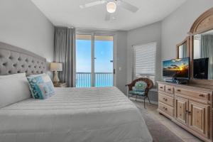 a bedroom with a bed with a television and a balcony at Summerwind Center 1304 in Navarre +44 photos