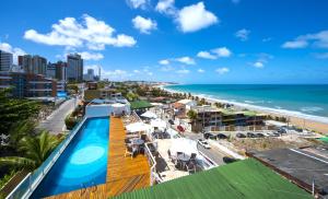 uma vista para a praia a partir da varanda de um resort com piscina em Vip Praia Hotel em Natal