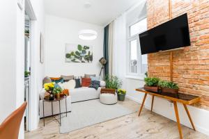 een woonkamer met een witte bank en een bakstenen muur bij Apartmany Albrechtice in Albrechtice nad Orlicí