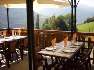 a table on a balcony with mountains in the background at Ferme Auberge du Bessard in Allevard