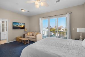 a bedroom with a large bed and a balcony at Bonita Bay in Pensacola Beach