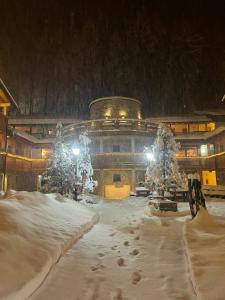 un edificio cubierto de nieve delante en Boscone Suite Hotel, en Madesimo