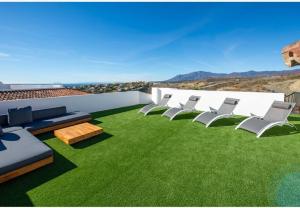a patio with chairs and grass on a roof at Paraiso Pueblo in Benahavís