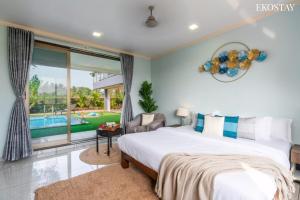 a bedroom with a large bed and a pool at EKOSTAY Luxe - Casa De Atlantis in Alibaug