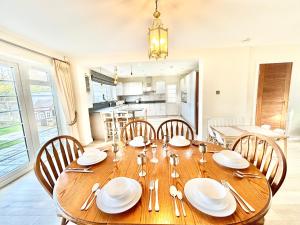 uma sala de jantar com uma mesa de madeira e cadeiras em Stonegrove Luxury House London Free Off Street Parking And EVC Port em Stone Grove