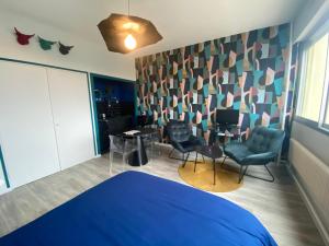 a bedroom with a bed and chairs and a table at Studio centre-ville in Montceau-les-Mines