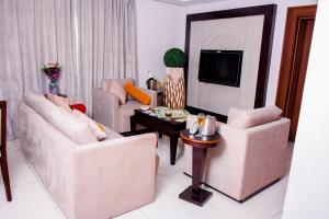 a living room with two couches and a tv at LIMEWOOD HOTEL in Port Harcourt
