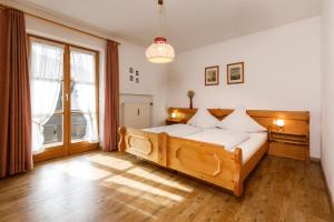 ein Schlafzimmer mit einem Holzbett und einem großen Fenster in der Unterkunft Haus Huis'n in Grainau