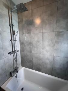 uma banheira branca na casa de banho com um chuveiro em Always the same price! Free parking em Londres