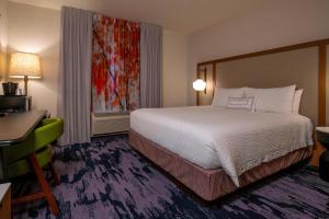 a hotel room with a large bed and a desk and a desk at Fairfield Inn & Suites by Marriott Venice in Venice