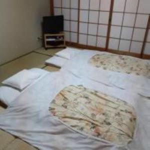 京都市にあるOHTO Ryokanのベッド(白いシーツ付)