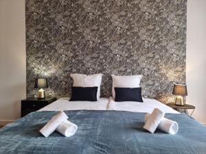 a bedroom with a bed with two pillows on it at Le chesterfield - coeur de ville in Épinal