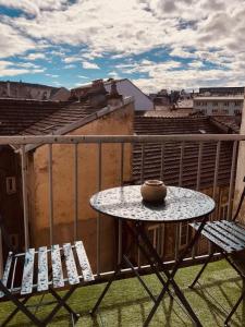 a table and chairs on a balcony with a view at Le chesterfield - coeur de ville in Épinal