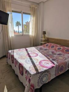オリフエラ・コスタにあるAppartement Orihuela Costa, Cabo Roigのベッドルーム1室(ベッド1台付)、ヤシの木のある窓が備わります。