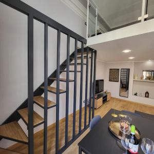 uma escada em espiral numa sala de estar com uma mesa em Appartamento Noemi Zinghouse CT em Catânia
