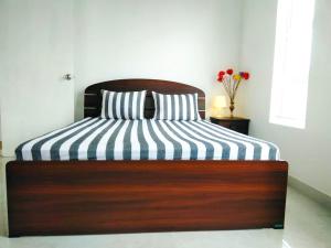 a bed with a black and white striped comforter at Millennium Elite in Opata