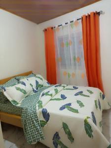 1 dormitorio con cama y cortina en RÉSIDENCE MEUBLÉE CYMAT en Douala