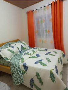 1 cama con edredón y almohadas en RÉSIDENCE MEUBLÉE CYMAT en Douala
