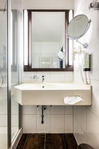 a bathroom with a sink and a mirror at Uferdeck - Boutique Hotel in Traben-Trarbach