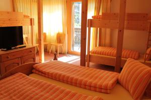 
a bedroom with two beds and a television at Pension St. Jakob in Engelberg
