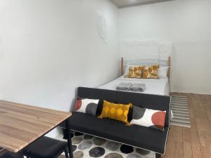 a small bedroom with a bed and a table at Cozy Studio Tobago in Scarborough